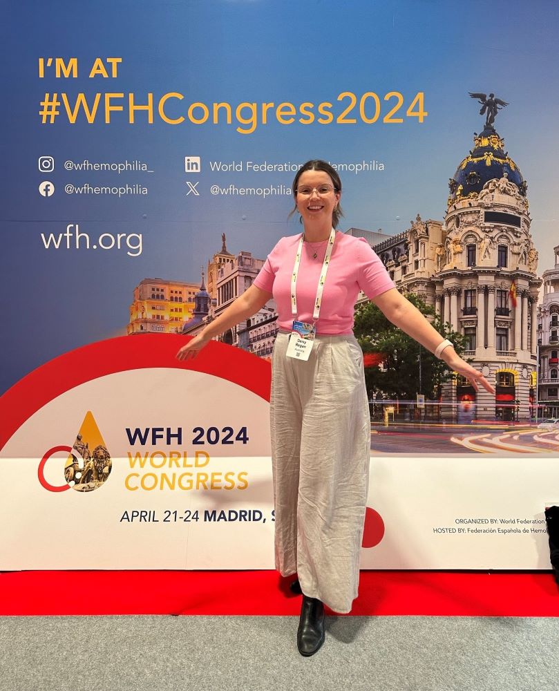 Daisy in front of the WFH Congress board